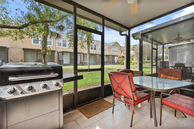 sunroom featuring a residential view and ceiling fan