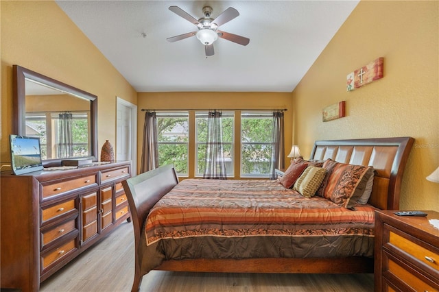 bedroom featuring lofted ceiling, a ceiling fan, and light wood-type flooring