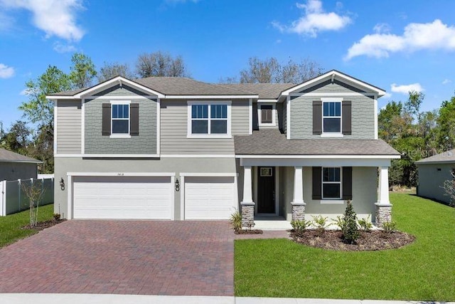 craftsman-style house featuring fence, a front yard, stucco siding, decorative driveway, and an attached garage