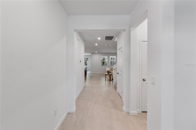 hallway with baseboards and visible vents