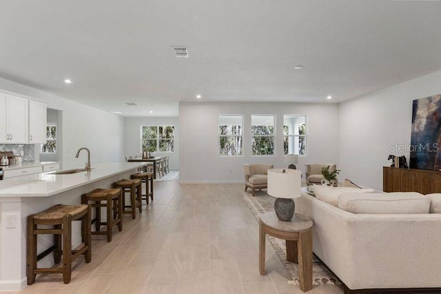 living room featuring recessed lighting and visible vents