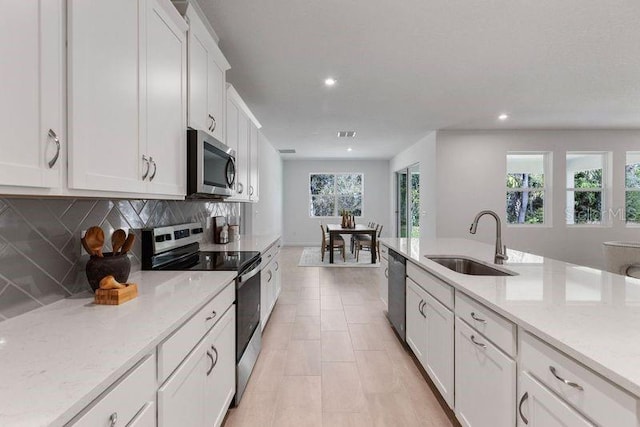 kitchen with a sink, white cabinetry, recessed lighting, appliances with stainless steel finishes, and decorative backsplash