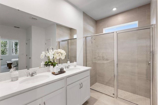 bathroom featuring double vanity, a stall shower, ensuite bath, and a sink