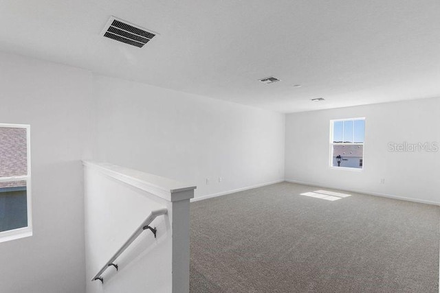 unfurnished room with carpet flooring, baseboards, and visible vents