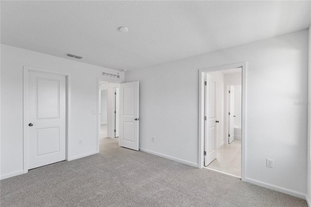 unfurnished bedroom with visible vents, baseboards, and carpet flooring