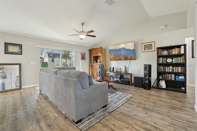 living area featuring lofted ceiling, visible vents, light wood finished floors, and ceiling fan