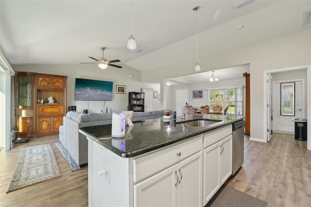 kitchen featuring light wood finished floors, a sink, open floor plan, vaulted ceiling, and stainless steel dishwasher