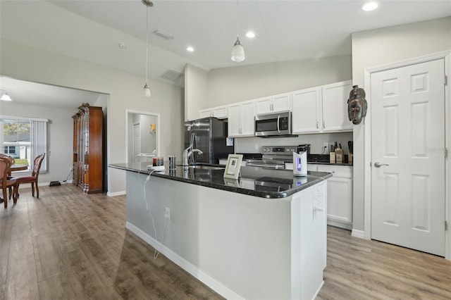 kitchen with white cabinets, wood finished floors, visible vents, and stainless steel appliances