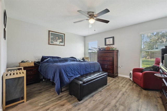 bedroom with baseboards, wood finished floors, and a ceiling fan