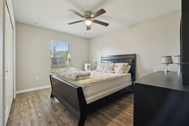 bedroom featuring baseboards, wood finished floors, and a ceiling fan