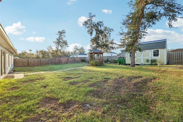 view of yard featuring a storage unit, an outdoor structure, and a fenced backyard