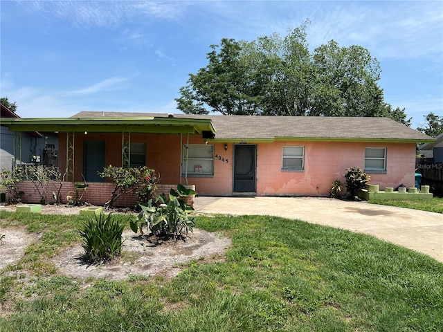 4845 Elese St, Orlando, FL 32811 - ranch-style home with concrete block siding, a front lawn, and roof with shingles
