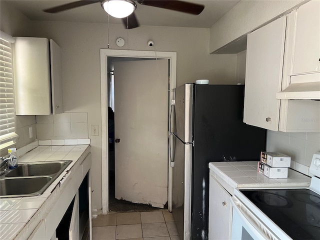 4845 Elese St, Orlando, FL 32811 - kitchen with white range with electric cooktop, tile countertops, a sink, and a ceiling fan