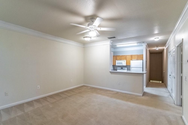 spare room featuring ceiling fan, light colored carpet, visible vents, and ornamental molding