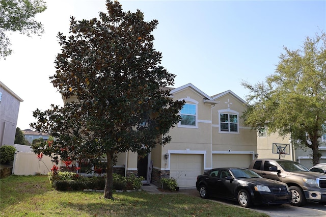 view of front of house featuring fence, driveway, an attached garage, stucco siding, and stone siding