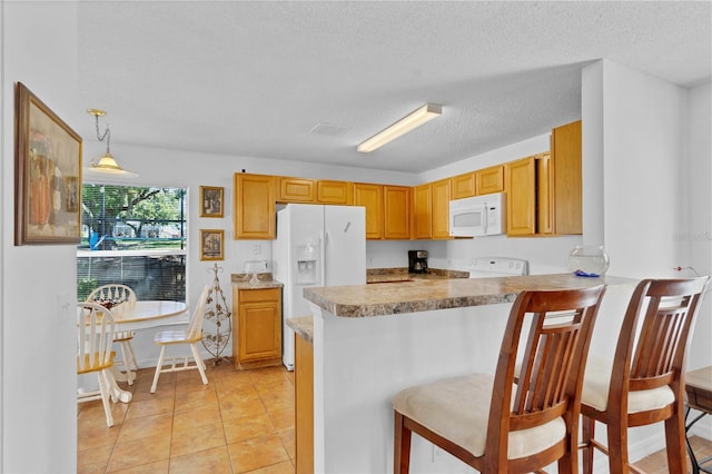 kitchen featuring white appliances, a textured ceiling, a peninsula, and light tile patterned flooring