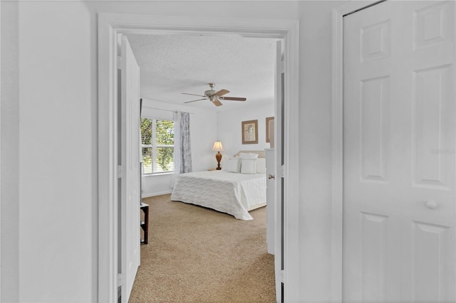 bedroom featuring baseboards, carpet flooring, a textured ceiling, and ceiling fan