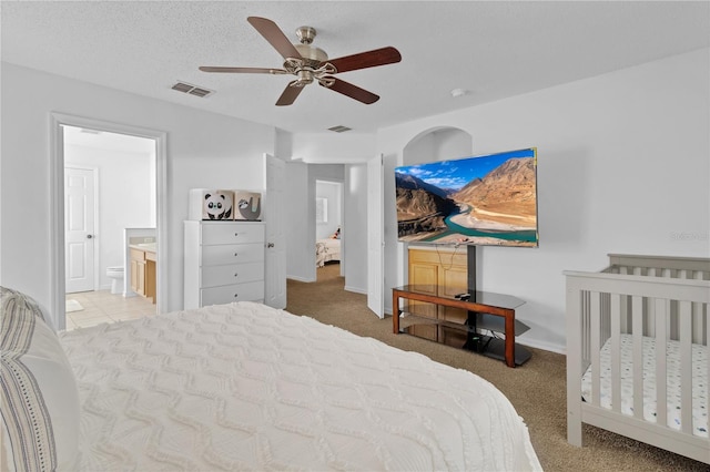 carpeted bedroom with visible vents, baseboards, a textured ceiling, and ceiling fan