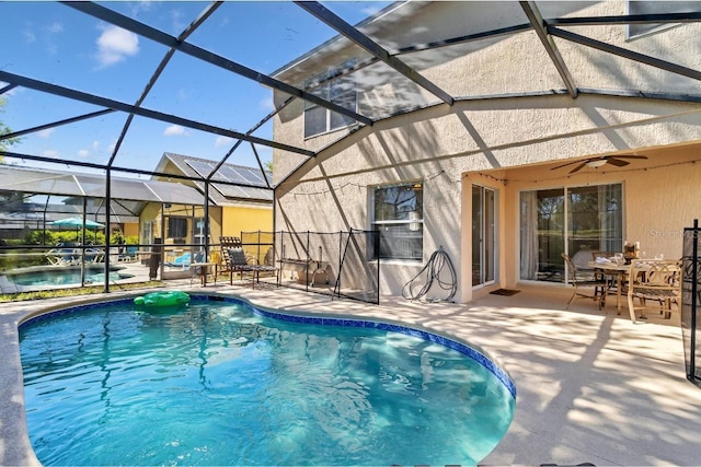 pool with a lanai, a ceiling fan, and a patio area