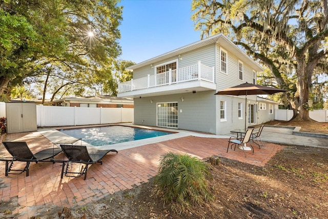 back of house with a patio area, a balcony, and a fenced backyard