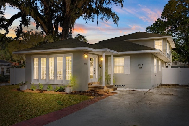 view of front of property featuring crawl space, a lawn, and fence