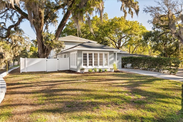 view of side of home featuring a gate, a yard, and fence