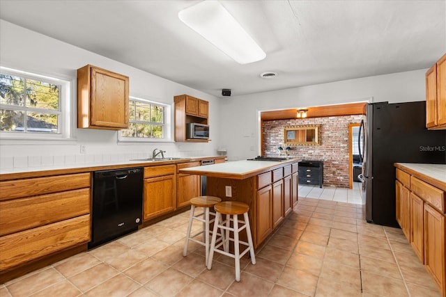 kitchen featuring a sink, light countertops, a kitchen island, and stainless steel appliances