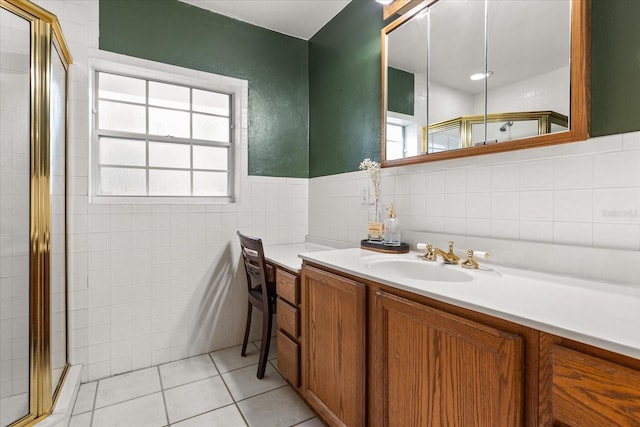 bathroom with a shower stall, a wainscoted wall, vanity, tile patterned floors, and tile walls