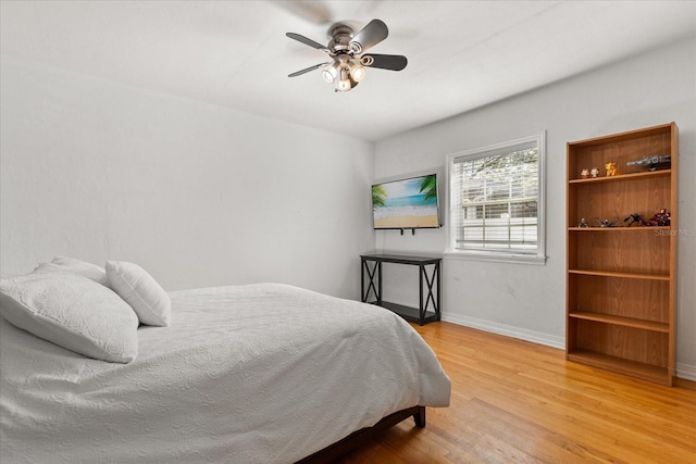 bedroom featuring wood finished floors, baseboards, and ceiling fan