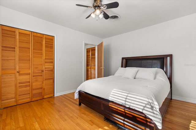 bedroom with visible vents, baseboards, light wood-style floors, and a closet