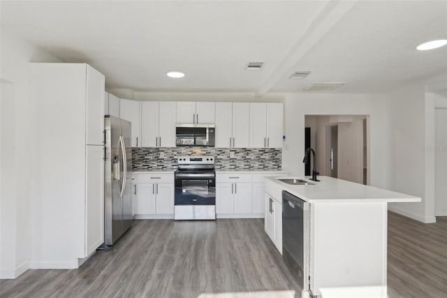 kitchen featuring visible vents, backsplash, light countertops, appliances with stainless steel finishes, and a sink