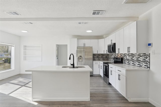 kitchen with a sink, wood finished floors, visible vents, and stainless steel appliances