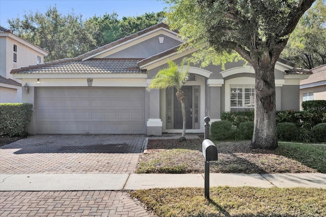 ranch-style house with stucco siding, decorative driveway, an attached garage, and a tile roof