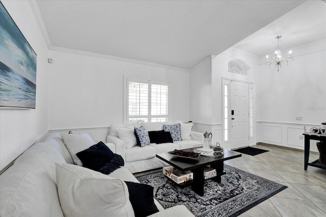 living area with a wainscoted wall, a notable chandelier, light tile patterned flooring, crown molding, and a decorative wall