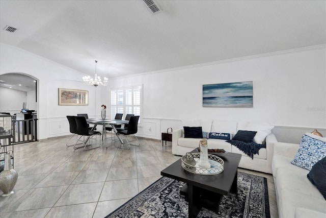 living room featuring arched walkways, visible vents, a decorative wall, and ornamental molding