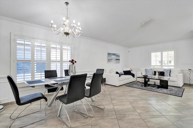 dining area with visible vents, crown molding, and an inviting chandelier