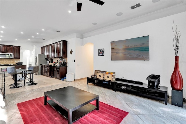 living room with visible vents, light tile patterned flooring, recessed lighting, arched walkways, and ceiling fan