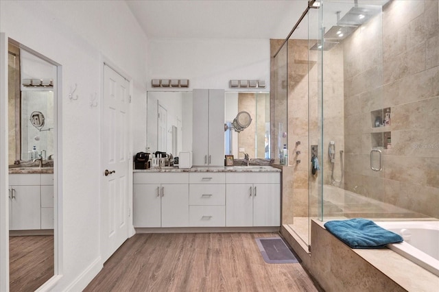 bathroom with wood finished floors, a stall shower, vanity, and a bath