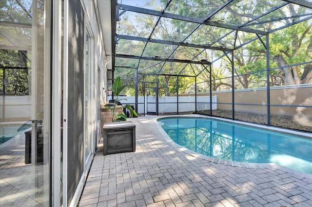 view of swimming pool featuring a fenced in pool, a patio, glass enclosure, and fence