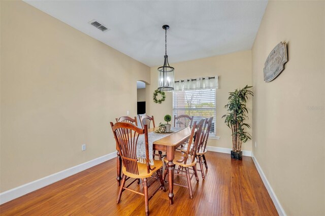 dining space featuring visible vents, baseboards, and wood finished floors