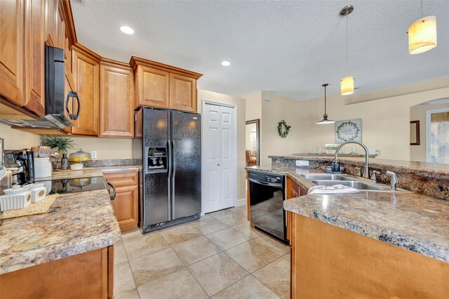 kitchen with black appliances, pendant lighting, brown cabinets, and a sink