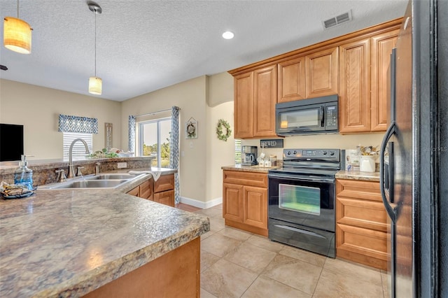 kitchen featuring visible vents, a sink, hanging light fixtures, black appliances, and a textured ceiling