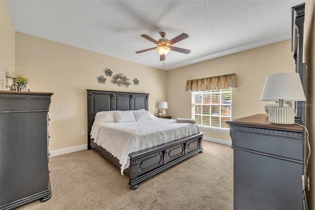 bedroom featuring a ceiling fan, light colored carpet, baseboards, and a textured ceiling