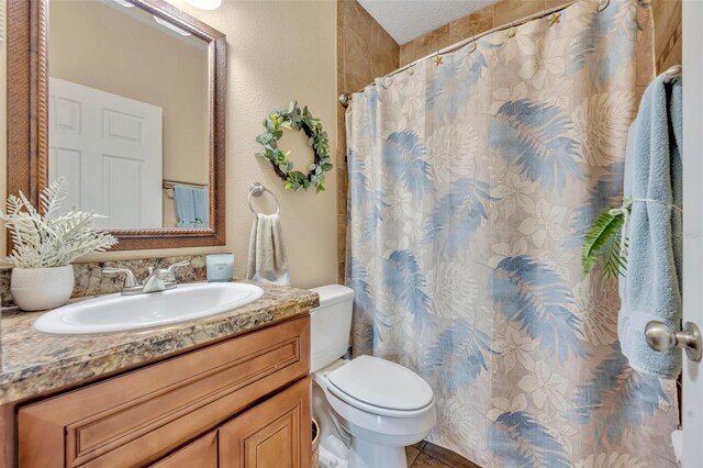 bathroom with toilet, vanity, and a shower with curtain
