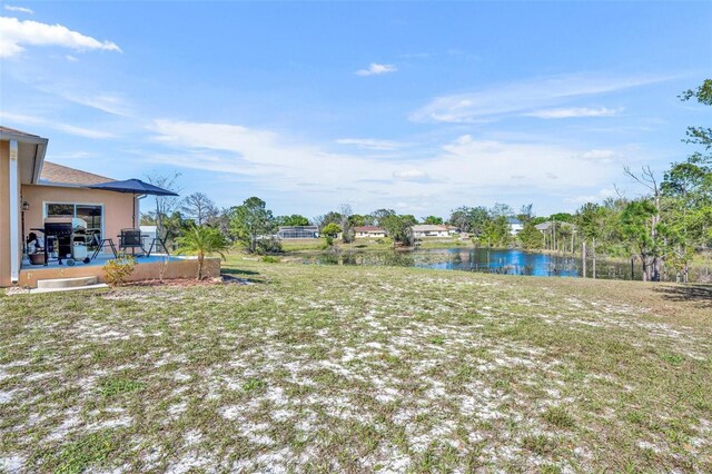 view of yard with a water view and a patio