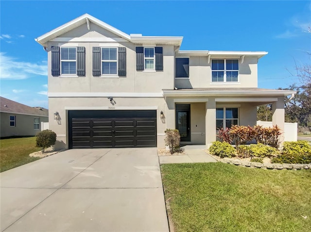 view of front of house with concrete driveway, a garage, a front yard, and stucco siding