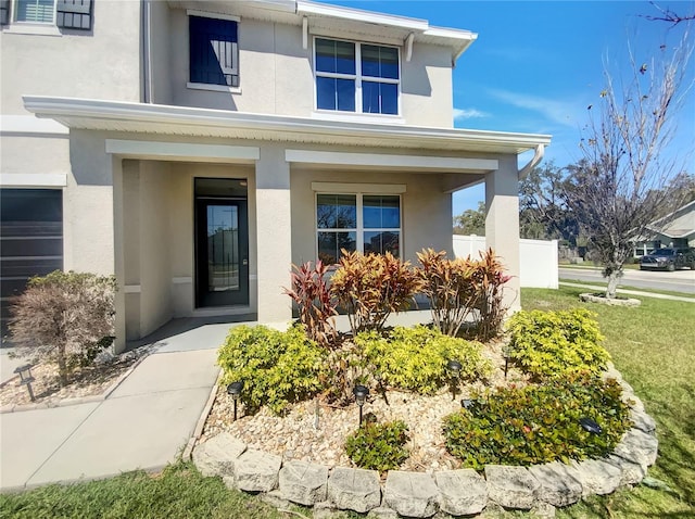 doorway to property featuring a porch and stucco siding