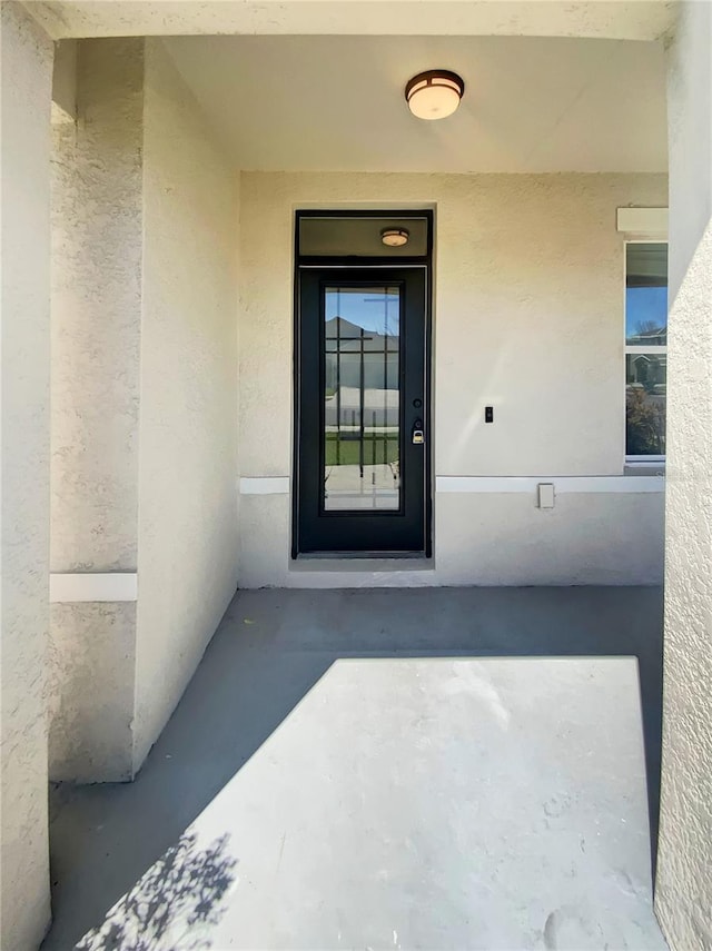 entrance to property featuring stucco siding