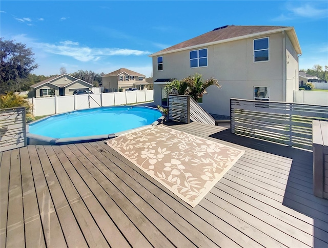 view of pool featuring a deck, a fenced in pool, a residential view, and a fenced backyard