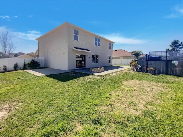 back of property with a yard, a fenced backyard, stucco siding, and a patio area